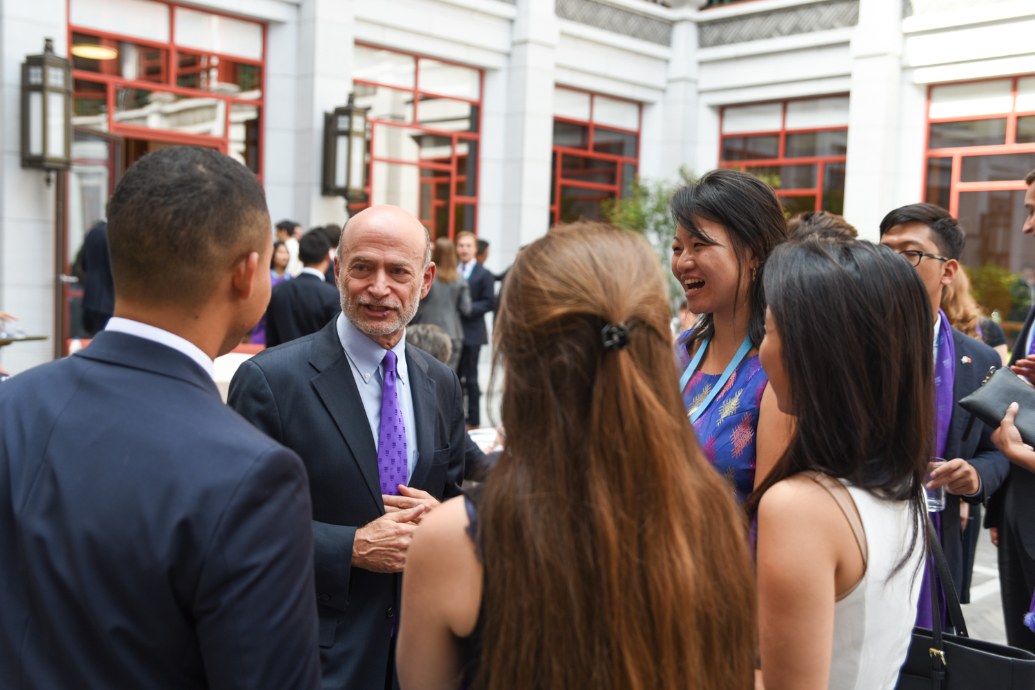 Administrator-speaking-to-group-of-students-outside-in-courtyard