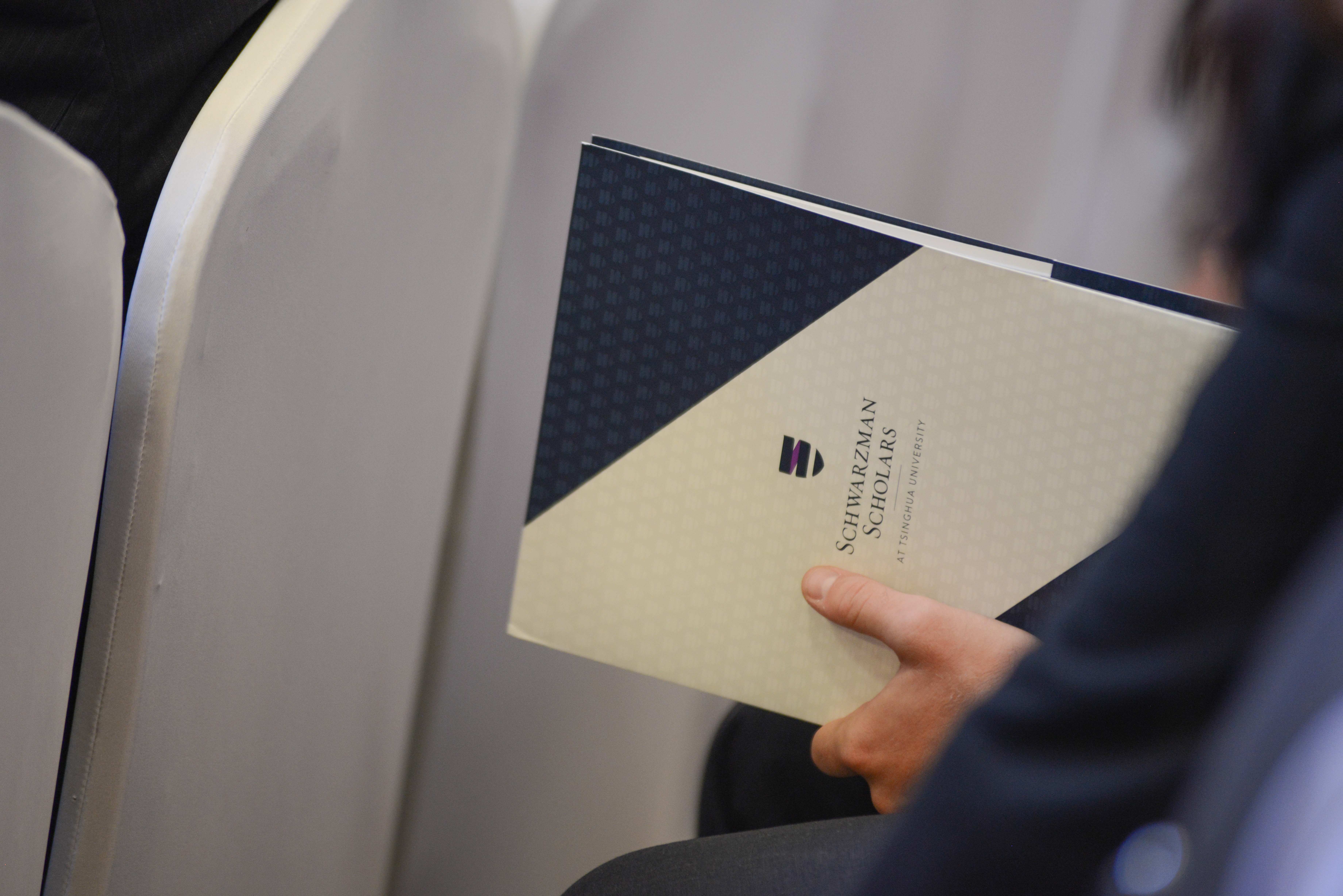 student holding Schwarzman Scholar documents